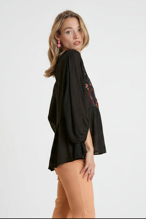 Embroidered peplum top with ruffled hemline and back keyhole