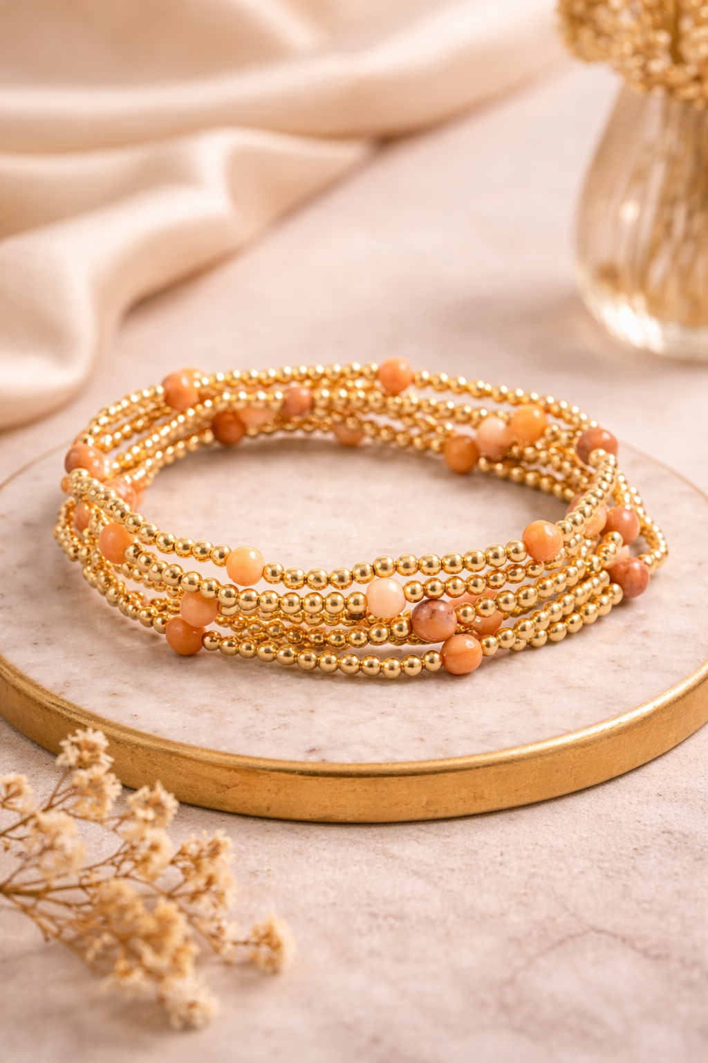 Stone and metallic beaded bracelets stacked on wrist